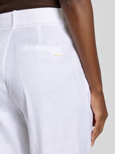 Frauenmodel trägt HOSE aus Leinen-Mix mit Bügelfalten Modell 'CARLA' von Guess, weiße Farbe, glatte Textur, Nahaufnahme Rückansicht, Damen Hose von Guess, Leinen-Mix mit Lyocell-Anteil, Regular-Fit, Bundweite bei Größe S 37 cm, Innenbeinlänge 89 cm.