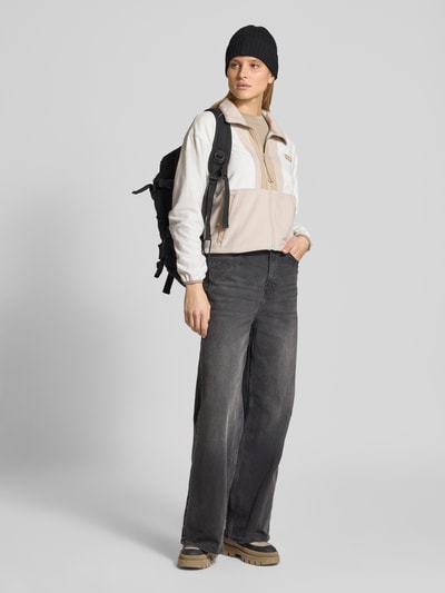 Modelka kobieca nosi Cropped Fleecejacke mit Label-Patch Modell 'Backbowl™' od Columbia, prosta forma, kieszenie, kolor beżowo-biały, całopostaciowy widok z przodu.