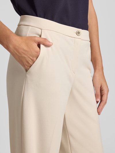 Vrouwenmodel draagt Hose mit Bügelfalten Modell 'Hillda' van STEHMANN in lichtbeige, materiaalmix met stretch, persplooien, detailopname heup.