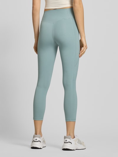 Vrouwenmodel draagt Leggings met Logo en elastische tailleband van adidas Sportswear in lichtblauw, nauwsluitende pasvorm, mix van stretchmateriaal, volledige lichaamsaanzicht achterkant.
