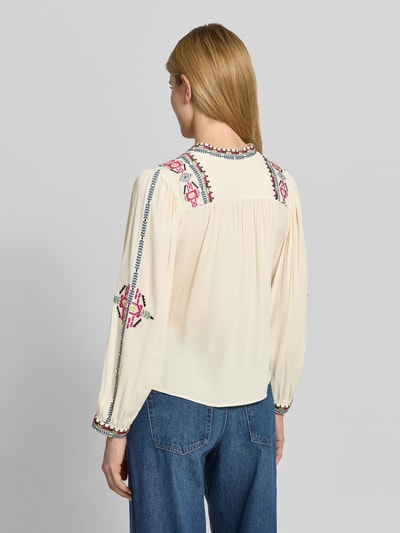 Frauenmodel trägt cremefarbene Tunikabluse mit Motiv-Stitching Modell 'TILT' von Bash aus Viskose, weit fallende Ärmel, Ganzkörperansicht Rückansicht.
