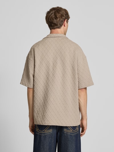 Männermodel trägt Modern Fit Freizeithemd mit Logo-Stitching Modell 'Jovren' von Pegador, Strukturmuster, Material-Mix, sandfarben, Ganzkörperansicht Rückansicht. Kontext: Herren Freizeithemd, Kentkragen, Knopfleiste, Rückenlänge bei Größe M 72 cm, Schulterbreite 61 cm, Ärmellänge 24 cm.