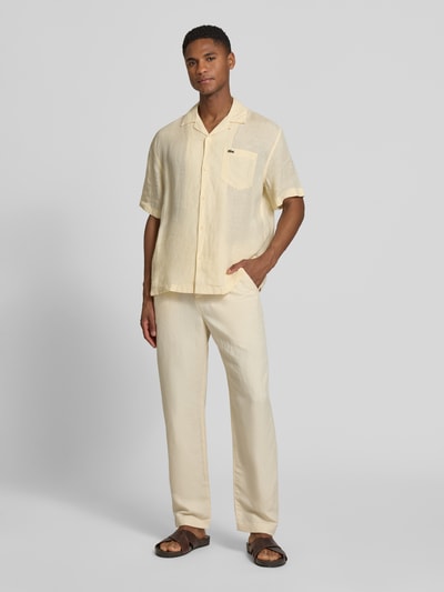 Männermodel trägt Straight Leg Stoffhose aus Leinen-Mix von Lacoste, cremefarben, unifarben, Flammgarn, Mid Waist, Ganzkörperansicht von vorne.