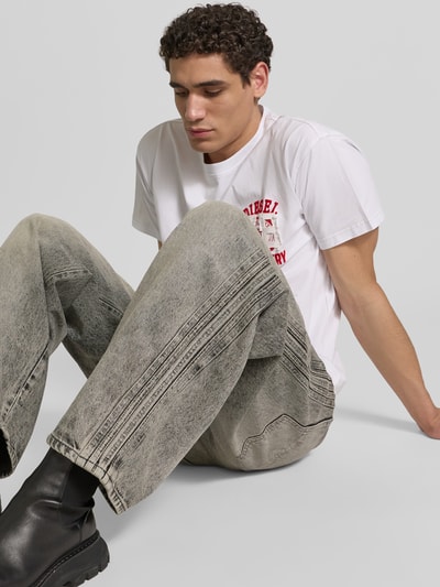 Männermodel trägt Loose Fit Jeans aus Baumwoll-Mix von Diesel in grau mit Label-Detail, 5-Pocket-Design, Ganzkörperansicht von vorne. Innenbeinlänge 80 cm, Bundweite 44 cm.