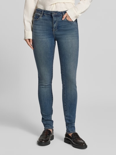 Frauenmodel trägt Skinny Fit Jeans mit Viskose-Anteil von Armani Exchange, 5-Pocket-Design, blau, Nahaufnahme Oberkörper bis Füße.
