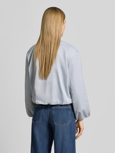 Modelka nosi Regular Fit Blouson mit Baseball-Kragen od Marc O'Polo, efekt: jednolity kolor, bufiaste rękawy, materiał z recyklingu, wpuszczane kieszenie, zamek błyskawiczny, wykończenie i rękawy z tunelem, krój regular fit. Zdjęcie: widok całej sylwetki z tyłu.