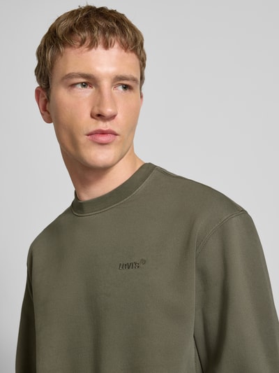 Männermodel trägt Sweatshirt mit Rundhalsausschnitt und Label-Stitching von Levi's®, olivgrün, reine Baumwolle, Regular Fit, Nahaufnahme Oberkörper.