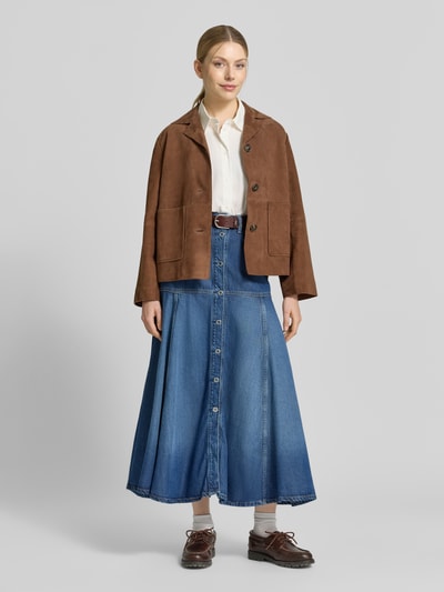Frauenmodel trägt Maxirock aus Lyocell-Mix in Denim-Optik Modell 'Nidia' von Guess in leichter A-Linie, 5-Pocket-Design, Ganzkörperansicht von vorne.