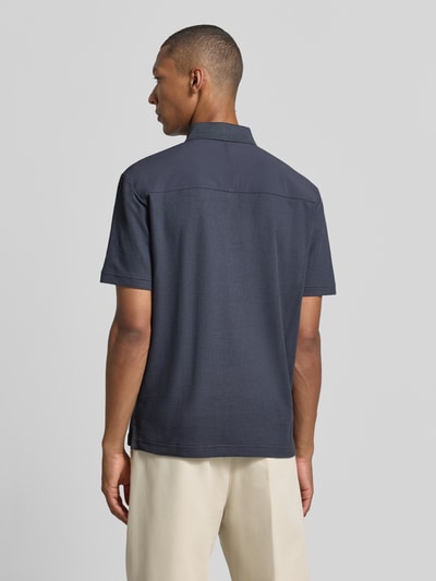 Mannermodel draagt donkerblauw regular fit poloshirt van katoen, model 'Pe_RibNylon' van BOSS Orange, Heren Ganzkörperansicht Rückansicht.