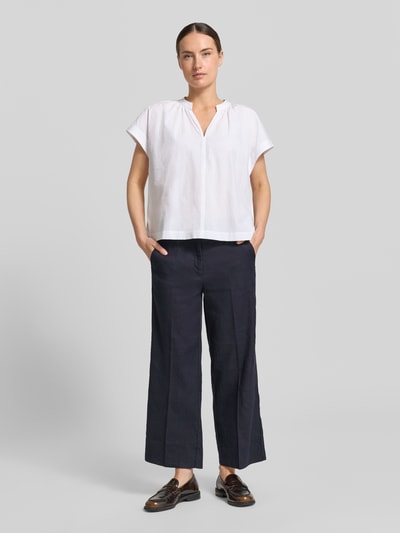 Kobiece model prezentuje chinosy z mieszanki lnu i bawełny Cambio, model 'CALIFORNIA', krój straight fit, kanty, zapięcie na haftkę i zamek błyskawiczny, wpuszczane kieszenie, kieszenie z tyłu, szerokość w rozmiarze 36: 41 cm, długość wewnętrzna nogawki w rozmiarze 36: 68 cm, widok całej sylwetki z przodu.