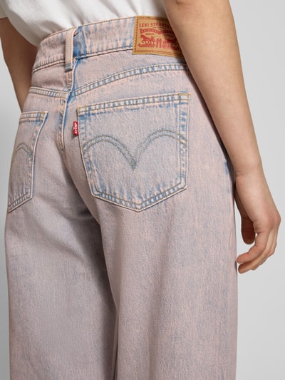 Frauenmodel trägt Superlow Loose Fit Jeans im Used-Look von Levi's®, reine Baumwolle, sichtbare Gesäßtaschen und Label, Nahaufnahme Rückansicht.
