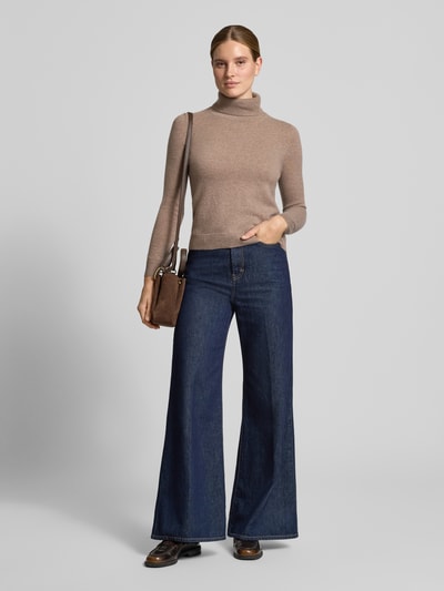 Frauenmodel trägt Regular Fit Rollkragenpullover aus reinem Kaschmir von Christian Berg Woman in Beige, gerippter Kragen, Ganzkörperansicht von vorne.