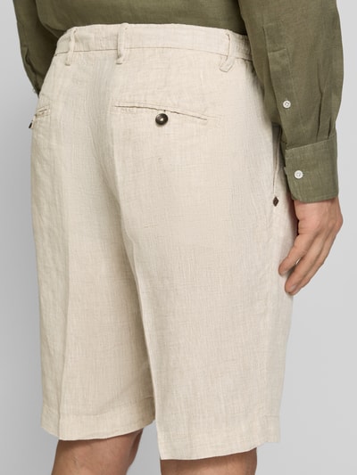 Mężczyzna nosi Shorts aus Leinen mit Eingrifftaschen von MARKUP, beżowe, krój straight fit, tekstura lnu, widok z tyłu, zdjęcie całej sylwetki. Szerokość w rozmiarze 50: 22 cm, długość nogawki wewnętrznej: 34 cm, kieszenie francuskie i tylne z zapięciem na guzik.