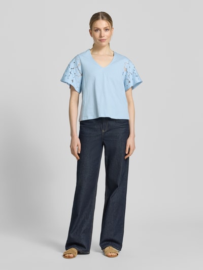 Frauenmodel trägt Regular Fit Blusenshirt aus reiner Baumwolle Modell 'VILLA' von Vero Moda in Hellblau, unifarben, Spitzenbesatz, Ganzkörperansicht von vorne