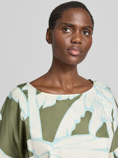 Kobiece modelka ma na sobie Regular Fit Blusenshirt im Allover-Look od Christian Berg Woman z bawełny, wzór na całej powierzchni, okrągły dekolt, długość tyłu w rozmiarze 36: 56 cm, długość rękawów w rozmiarze 36: 25 cm, kolor zielony i kremowy, gładka tekstura, zbliżenie górnej części ciała.