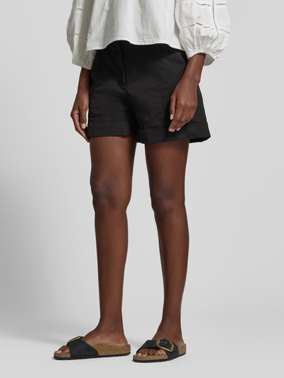 Frauenmodel trägt Relaxed Fit Shorts aus Baumwoll-Mix Modell 'TANESSA-D' von BOSS Orange in Schwarz mit Gürtelschlaufen, Nahaufnahme Unterkörper.
