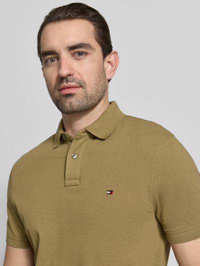 Männermodel trägt Regular Fit Poloshirt aus Baumwoll-Mix von Tommy Hilfiger, Optik: Unifarben, Logo-Stitching, Piqué, Nahaufnahme Oberkörper.