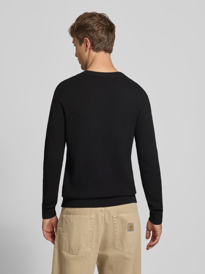 Männermodel trägt zwarte gebreide pullover van puur katoen Model 'Ryder' van JACK & JONES, slim fit, label-logo, met lange mouwen, ribboorden, tricotlook, ronde hals, ruglengte maat M: 73 cm, mouwlengte maat M: 71 cm, gebreid design, effen, Ganzkörperansicht Rückansicht.