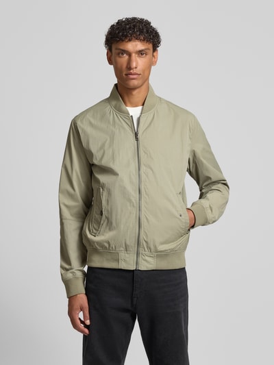 Männermodel trägt Regular Fit Bomberjacke mit Stehkragen von s.Oliver RED LABEL in Beige, strukturierte Optik, Ganzkörperansicht von vorne.
