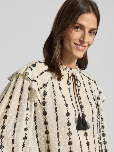 Frauenmodel trägt Regular Fit Bluse mit Stitchings von More & More, cremefarben mit schwarzen Stickereien, Schlüsselloch-Ausschnitt, Nahaufnahme Oberkörper. Rückenlänge 62 cm, Ärmellänge 59 cm bei Größe 36.