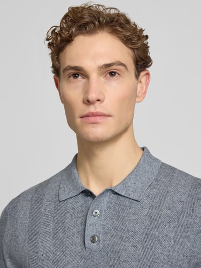 Męski model nosi Slim Fit Poloshirt mit Knopfleiste von Profuomo z mieszanki bawełny i lnu, fakturowany wzór, krój slim fit, listwa guzikowa, długość tyłu w rozmiarze M 70 cm, kolor szary, faktura wyraźna, prosty krój, Nahaufnahme górnej części ciała.