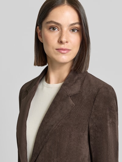 Frauenmodel trägt Regular Fit Blazer in Cord-Optik von COMMA, braune Farbe, sichtbare Cordstruktur, Nahaufnahme Oberkörper, elastischer Material-Mix, Reverskragen, KI-modifiziertes Bild.
