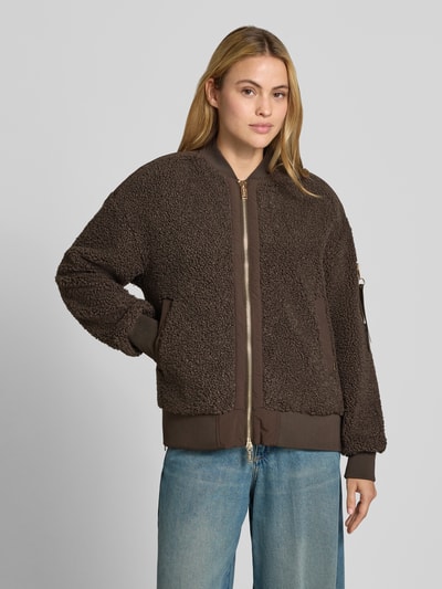 Frauenmodel trägt Teddyjacke mit Stehkragen Modell 'Emeline' von MOS MOSH in Braun, strukturierte Oberfläche, lockere Passform, Nahaufnahme Oberkörper. Damenjacke mit Reißverschlusstasche am Ärmel, Zweiwege-Reißverschluss, seitliche Eingrifftaschen, elastische Abschlüsse, Label-Detail.