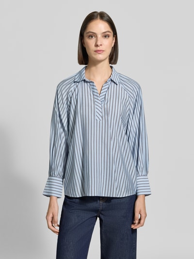 Vrouwenmodel draagt Relaxed Fit blouse uit viscosemix met blauw-wit streeppatroon, platte kraag en lange mouwen van zero, ruglengte maat 36: 66 cm, mouwlengte: 59 cm, blouse met lange mouwen, platte kraag, effen denimbroek, kleuren blauw en wit, materiaal met zachte textuur, voorkant volledige bodyopname.