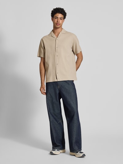Männermodel trägt Regular Fit Freizeithemd mit Strukturmuster Modell 'Global' von Jack & Jones, beige Farbe, Ganzkörperansicht von vorne.