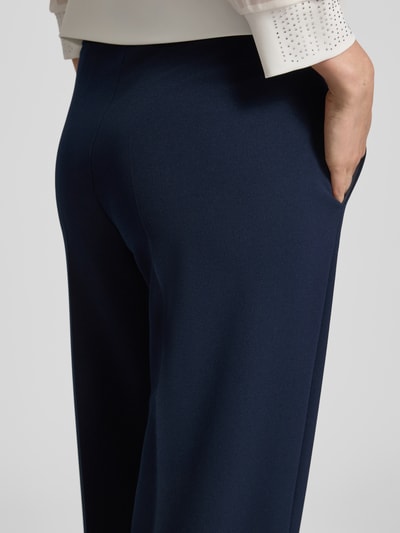 Frauenmodel trägt Stoffhose mit Bügelfalte und elastischem Bund von Vera Mont, dunkelblauer Material-Mix mit Stretch-Anteil, Nahaufnahme Rückansicht.
