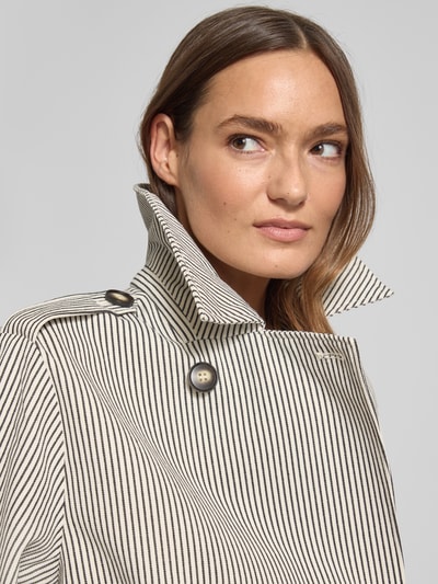 Kobiece model prezentuje Relaxed Fit Kurtka z wykładanym kołnierzem Model 'Becker' od mbyM, mieszanka bawełny, wpuszczane kieszenie, podwójna listwa guzikowa, długość tyłu w rozmiarze S: 58 cm, szerokość ramion w rozmiarze S: 42 cm, szerokość klatki piersiowej w rozmiarze S: 49 cm, długość rękawów w rozmiarze S: 59 cm, jasna tkanina w czarne paski, wyraźna tekstura, zbliżenie na górną część ciała.