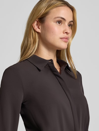 Vrouwenmodel draagt Blusenshirt met Umlegekragen van Rinascimento in effen donkerbruin, recht model, lange mouwen, knoopsluiting, detailopname bovenlichaam.