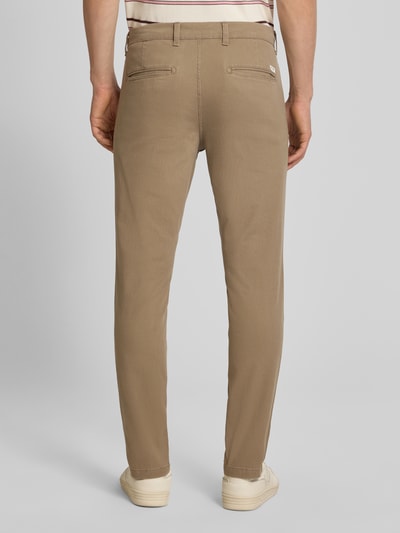 Męski model nosi Slim Fit spodnie z kieszeniami z tyłu Model 'MARCO' od Jack & Jones, mieszanka bawełny i elastanu, krój slim fit, Szerokość w rozmiarze 32/32: 43 cm, Długość wewnętrzna nogawki: 77 cm, beżowy kolor, tekstura gładka, widok całej sylwetki z tyłu.