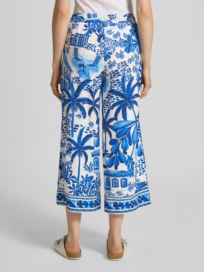 Vrouwenmodel draagt Culotte aus Viskose-Mix mit elastischem Bund van Christian Berg Woman met blauw-wit tropisch dessin, uitlopend model, steekzakken, comfortabele band met tunnelkoord, modelinformatie: bandwijdte maat 36 is 39 cm, binnenbeenlengte 61 cm, geheelbeeld achteraanzicht.