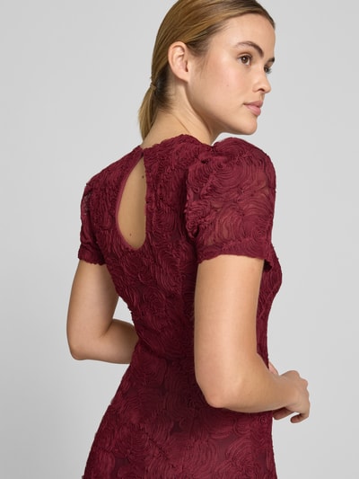 Frauenmodel trägt Maxikleid mit floralem Allover-Besatz von ROTATE aus Elastischer-Material-Mix, taillierte Passform, Kurzärmelig, Rückenansicht, Nahaufnahme Oberkörper.