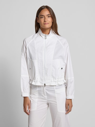 Frauenmodel trägt Regular Fit Jacke mit Stehkragen von Marc Cain aus Baumwoll-Mix mit Zweiwege-Reißverschluss und Druckknopfverschluss, Ganzkörperansicht von vorne. Rückenlänge bei Größe 36: 54 cm, Schulterbreite: 40 cm, Brustweite: 60 cm, Ärmellänge: 72 cm, elastische Ärmelabschlüsse, Tunnelzug im Bund, Eingrifftaschen.