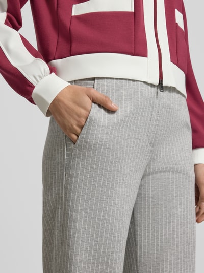 Frauenmodel trägt Wide Fit Stoffhose aus Viskose-Mix von Marc Cain, grau mit feinen weißen Streifen, elastischer Bund, Nahaufnahme Hüfte.