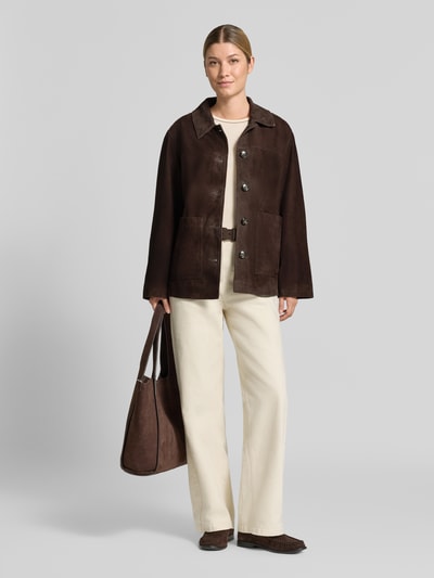 Frauenmodel trägt Lederjacke mit aufgesetzten Taschen von COMMA in Dunkelbraun mit Umlegekragen, Knopfleiste und Regular Fit, Ganzkörperansicht von vorne.