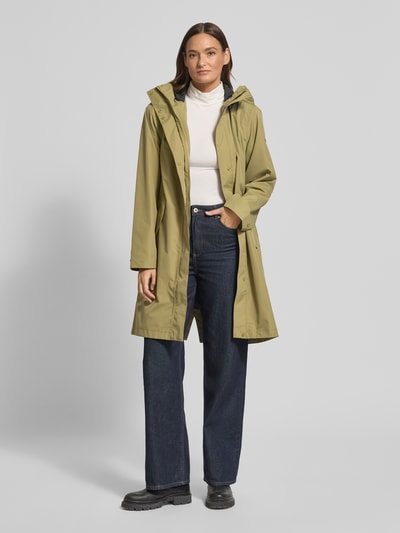 Frauenmodel trägt Parka mit Pattentaschen Modell 'ELINA' von Didriksons in Olivgrün, Relaxed-Fit, mit Kapuze und Tunnelzug, Ganzkörperansicht von vorne, Rückenlänge bei Größe 36: 97 cm, Schulterbreite: 41 cm, Brustweite: 53 cm, Ärmellänge: 64 cm.