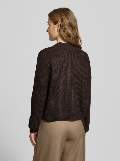 Frauenmodel trägt Regular Fit Strickjacke mit einreihiger Knopfleiste Modell 'CAROL NICE' von Only, Strickoptik, unifarben, Ganzkörperansicht Rückansicht.