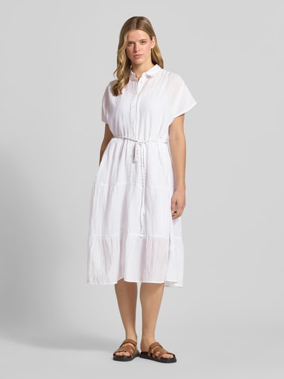 Frauenmodel trägt weißes Tailliertes Blusenkleid aus reiner Baumwolle Modell 'FANCY DRESS' von Pepe Jeans, strukturierte Optik, Ganzkörperansicht von vorne, Damen Blusenkleid.