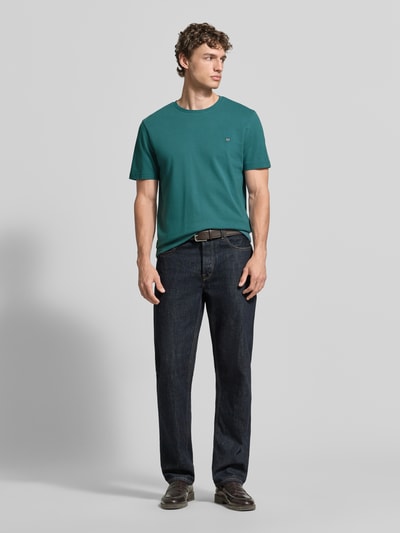 Männermodel trägt T-Shirt aus Baumwolle mit Rundhalsausschnitt von Christian Berg Men in Regular-Fit, Label-Detail, Rückenlänge 71 cm, Ganzkörperansicht von vorne.