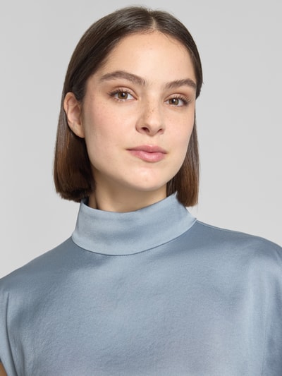 Kobiece model prezentuje Blusenshirt mit Stehkragen Modell 'ALARIA' od Drykorn, mieszanka materiałów z dodatkiem streczu, krój regular fit, długość tyłu w rozmiarze 36: 59 cm, jasnoniebieski odcień, gładka tekstura, zbliżenie na górną część ciała