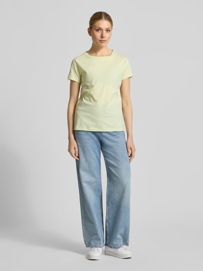 Frauenmodel trägt Slim Fit T-Shirt aus reiner Baumwolle Modell 'ELOVE_EMBRO' von BOSS Orange in unifarbenem Gelb, Rundhals, Kurzarm, Label-Stitching, Ganzkörperansicht von vorne