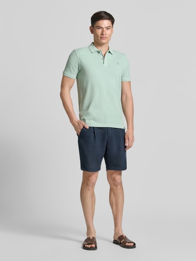 Männermodel trägt Slim Fit Poloshirt mit Logo-Stitching von Lerros, Baumwoll-Mix, Polokragen, Knopfleiste, Rückenlänge 74 cm, Ganzkörperansicht von vorne.