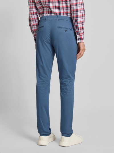 Männermodel trägt Slim Fit Chino aus Baumwoll-Mix Modell 'BLEECKER' von Tommy Hilfiger, niebieski, gładki, widok całej sylwetki tyłem.