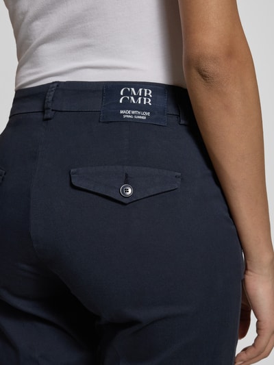 Frauenmodel trägt Straight Fit Stoffhose mit Bügelfalten Modell 'Karina' von Cambio, dunkelblauer Baumwoll-Mix, Gesäßtaschen, Nahaufnahme Rückansicht.