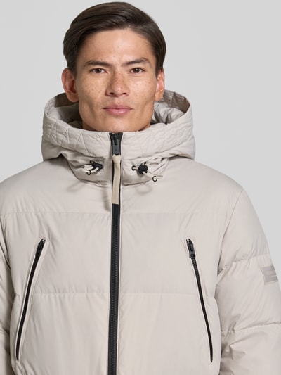 Männermodel trägt Regular Fit Daunenjacke mit Kapuze von Marc O'Polo, unifarben, label patch, wasserabweisend, Nahaufnahme Oberkörper.