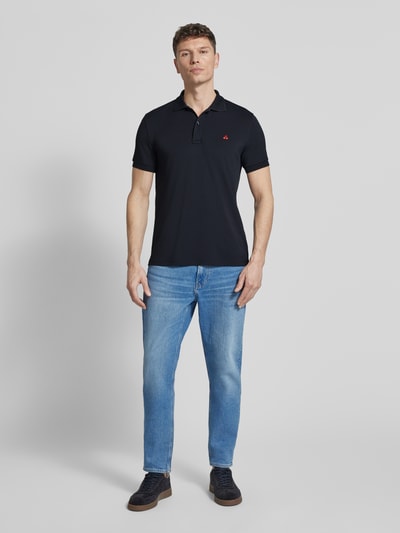Męski model nosi Regular Fit Koszulkę polo z haftem model 'PLANTAGO' od Peuterey, mieszanka materiałów z dodatkiem streczu, kołnierzyk polo, listwa guzikowa, długość tyłu w rozmiarze M: 71 cm, ciemny granat, gładka tekstura, krój regular fit, całkowity widok z przodu.
