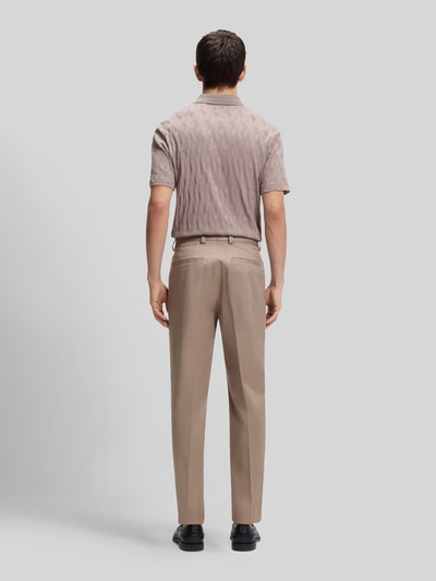 Männermodel trägt Slim Fit Bundfaltenhose aus Baumwoll-Mix Modell 'GENRICH' von HUGO in Optik: Unifarben, Ganzkörperansicht Rückansicht.